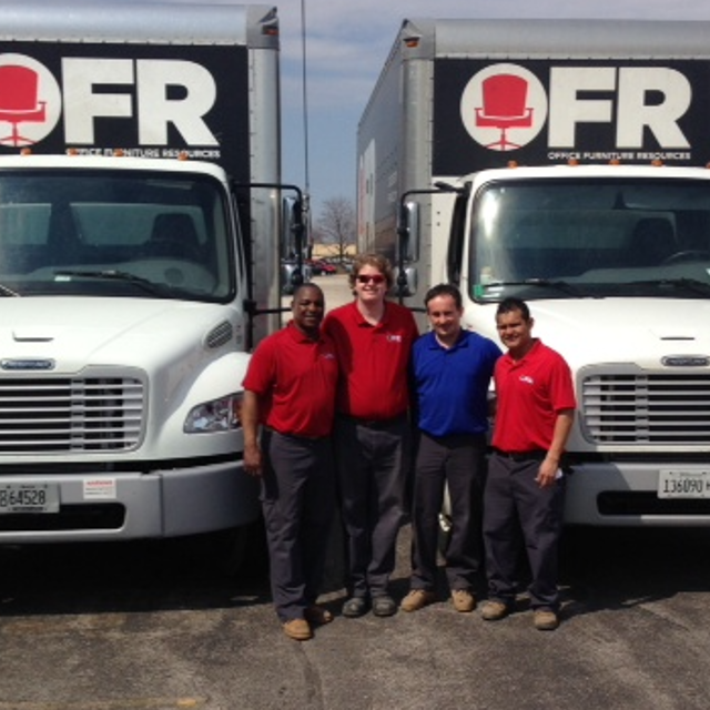 Image of OFR Staff standing in front of office furniture delivery trucks