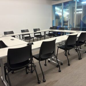 An office space with stacking chairs and flip and nest tables.