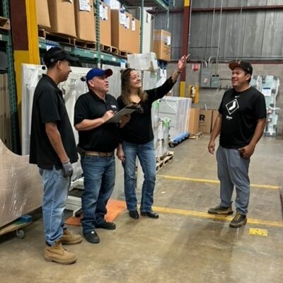 Angela in the warehouse with staff Angela in the warehouse with staff